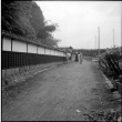 Group standing on dirt road outside wall (ddr-densho-426-2479)