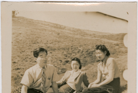 Henri Takahashi (l), unknown women and Tomoye (Nozawa) Takahashi sitting in a field (ddr-densho-426-1943)