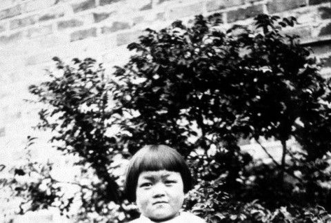 Girl standing outside a house (ddr-densho-18-74)