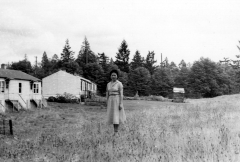Woman in front of housing project home (ddr-densho-2-16)