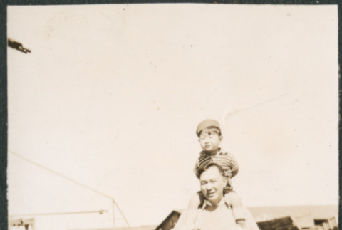 Man with child on his shoulders, with dog (ddr-densho-523-74)