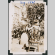 Boy standing on chair in garden. (ddr-densho-483-580)