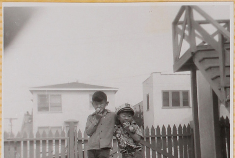 William Shiomi with unidentified boy eating apples (ddr-densho-522-283)