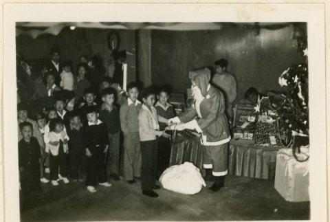 Santa Claus hands out gifts to children (ddr-densho-37-1304)