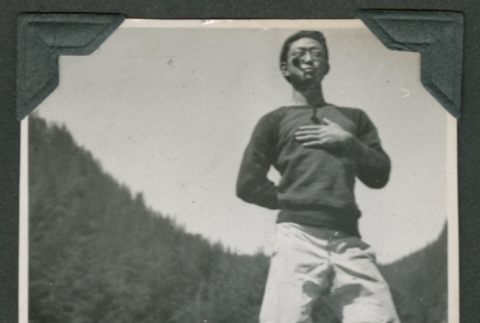 Man standing on rock with hand over heart (ddr-densho-540-97)