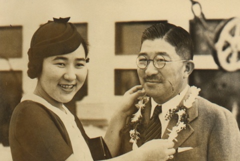 Young woman placing a lei on a man (ddr-njpa-4-95)