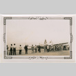 Group with U.S. and Japanese flags standing by airplane on a runway (ddr-densho-426-1929)