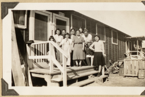 Group poses on the steps of the Kikawa barrack (ddr-densho-542-407)