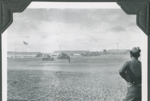 Man standing in field looking at tanks (ddr-ajah-2-177)