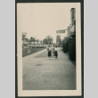 Women walk down the sidewalk at Jantzen Beach Amusement Park. (ddr-densho-359-181)