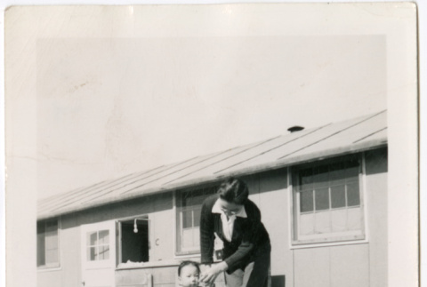 Sally Domoto walking with toddler outside barracks (ddr-densho-329-1340)