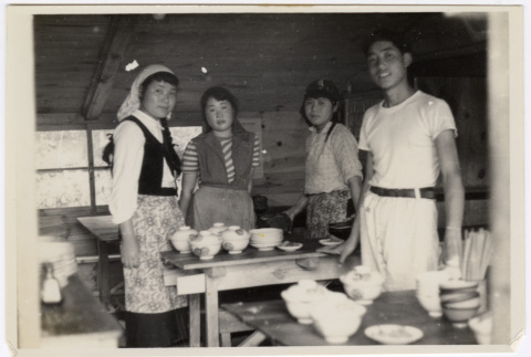 Four people standing around a table (ddr-densho-433-719)