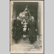 Two women and a girl holding a doll by Christmas tree (ddr-densho-293-73)