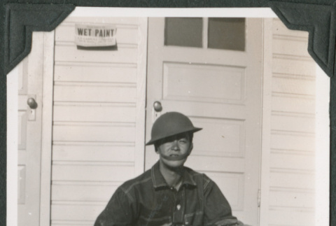 Man sitting on steps holding rifle (ddr-ajah-2-141)