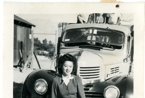 Woman standing in front of a truck (ddr-manz-6-84)