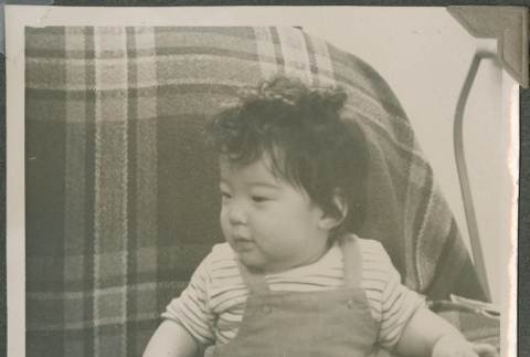 A baby sitting on a couch (ddr-densho-201-989)