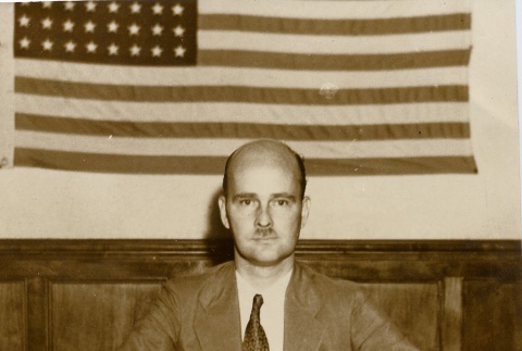 Man seated at a desk holding a gavel (ddr-njpa-2-582)