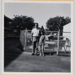 Man and girl standing by swimming pool (ddr-densho-522-122)