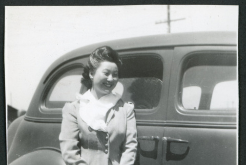 Photograph of Echo Goto leaning on a car at Manzanar (ddr-csujad-47-263)