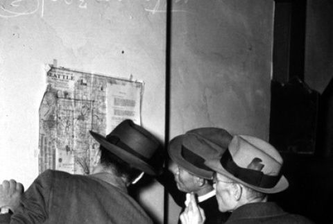 Three men looking at a mass removal map (ddr-densho-36-48)