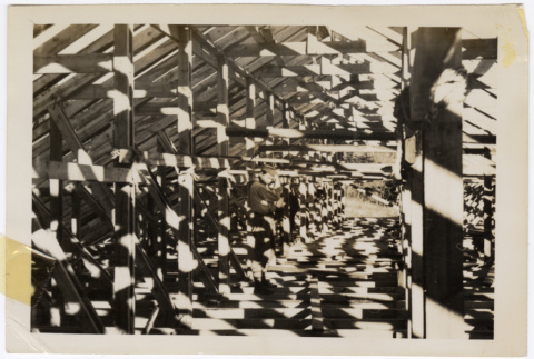 Man under frame of a roof (ddr-densho-433-714)