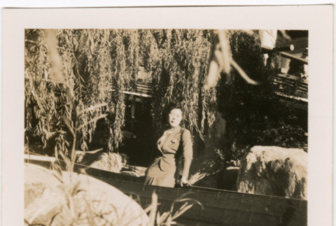 Tomoye (Nozawa) Takahashi standing in garden (ddr-densho-426-2117)
