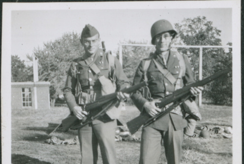 Two men with packs holding rifles (ddr-densho-434-466)