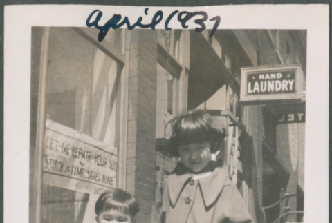 Boy and girl standing on sidewalk outside laundry (ddr-densho-483-683)