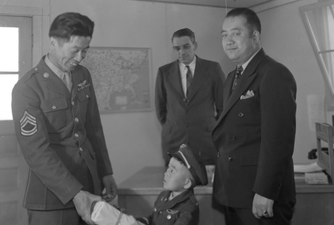 Ben Kuroki receiving a gift from a boy dressed as a soldier (ddr-fom-1-362)