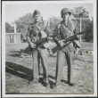 Two men with packs holding rifles (ddr-densho-434-466)