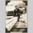 Isamu Ito sitting along edge of boardwalk (ddr-densho-383-254)