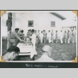 Men lined up by table of food and beer (ddr-densho-434-370)