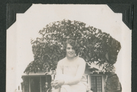 woman sitting on hood of card (ddr-densho-378-482)