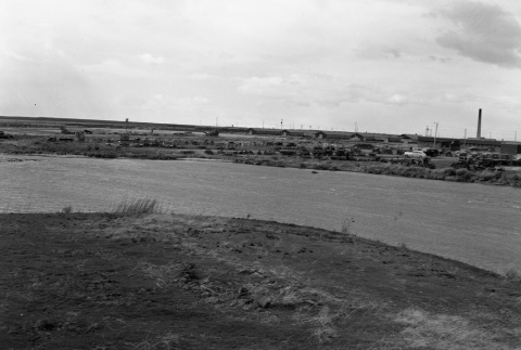Field of vehicles and heavy equipment with barracks in the background (ddr-fom-1-707)