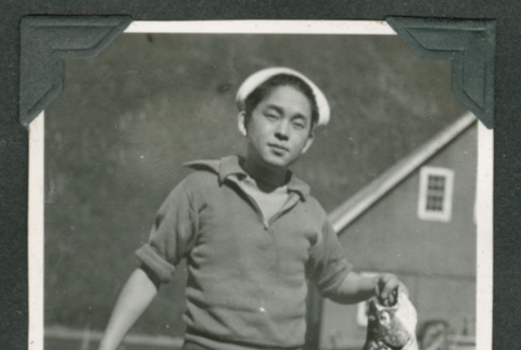 Tets Oye holding small fish (ddr-densho-540-84)