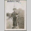 Toddles in sweater and hat standing on sidewalk (ddr-densho-483-695)