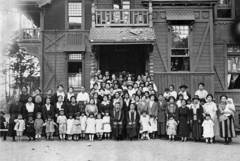 Large group of adults and children posing outside building (ddr-ajah-3-171)
