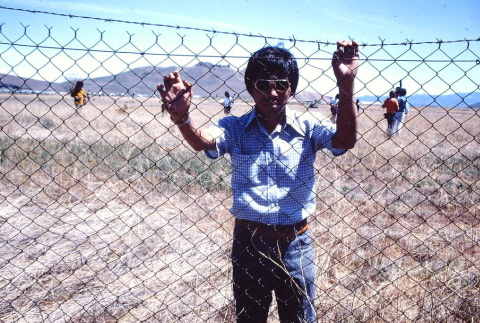 A man behind barbed wire at Tule Lake (ddr-densho-294-56)