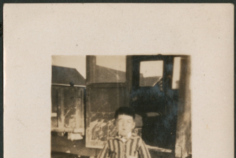 Boy in striped shirt standing by car (ddr-densho-316-239)