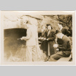 Two women and three men standing by large outside fireplace (ddr-densho-426-1861)