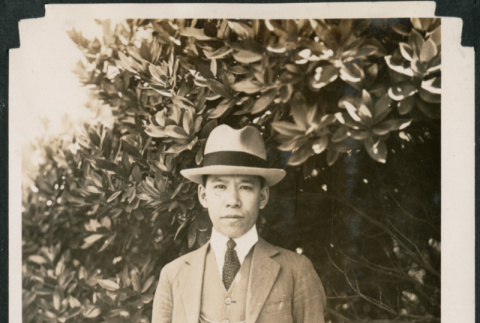 Man in a suit beside a tree (ddr-densho-483-560)