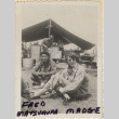 Man and woman in Red Cross uniform sitting outside mess tent (ddr-densho-466-373)