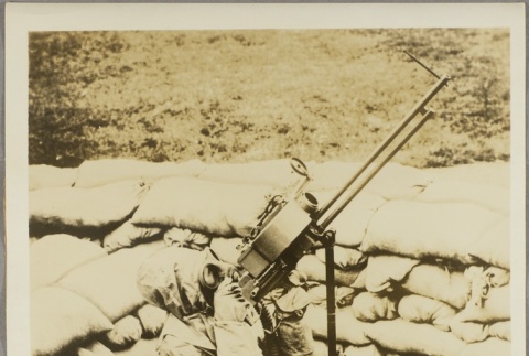 A soldier in a protective suit aiming a machine gun (ddr-njpa-13-1524)