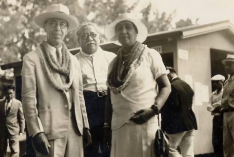 Victor S. K. Houston and wife wearing leis, posing with another man (ddr-njpa-2-432)