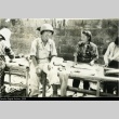 Nisei soldier with Okinawan women doing laundry (ddr-densho-179-145)