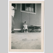 Little girl in bonnet outside barracks (ddr-densho-329-1348)