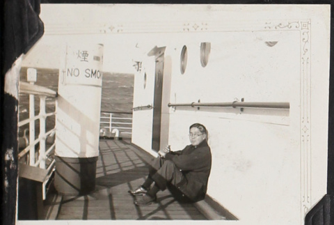 Man sitting on deck of ship (ddr-densho-326-356)