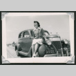 Tsuruko Mizusawa sitting on car (ddr-densho-550-137)