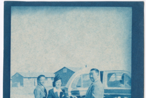 Two men and a woman standing by taxi (ddr-densho-329-1359)