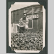 Man atop log pile outside Mess 19 (ddr-densho-471-58)